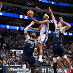 Jan 1, 2026; Dallas, Texas, USA; Philadelphia 76ers guard Vj Edgecombe (77) drives to the basket past Dallas Mavericks forward Daniel Gafford (21) and forward Cooper Flagg (32) during the second half at the American Airlines Center. Mandatory Credit: Jerome Miron-Imagn Images