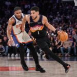 New York, New York, USA; Phoenix Suns guard Devin Booker (1) brings the ball up court while defended by New York Knicks guard Miles McBride (2) during the second half at Madison Square Garden. Mandatory Credit: John Jones-Imagn Images