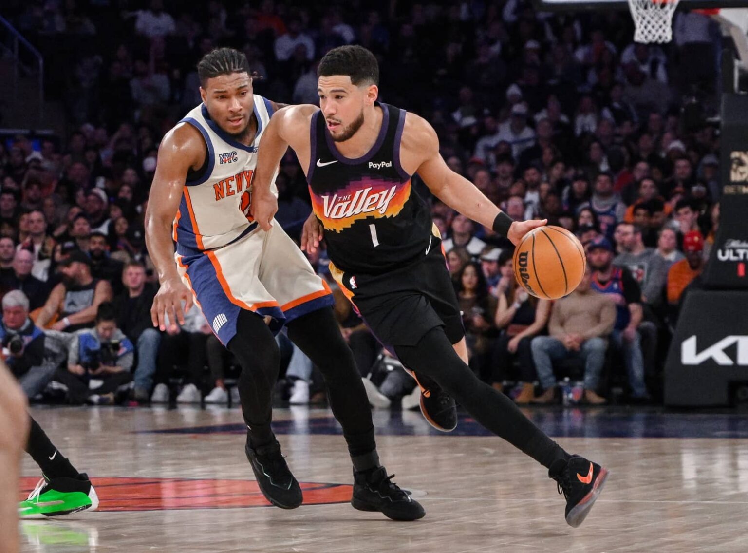New York, New York, USA; Phoenix Suns guard Devin Booker (1) brings the ball up court while defended by New York Knicks guard Miles McBride (2) during the second half at Madison Square Garden. Mandatory Credit: John Jones-Imagn Images