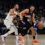 Phoenix, Arizona, USA; Phoenix Suns guard Devin Booker (1) controls the ball against New York Knicks guard Jalen Brunson (11) in the first half at Mortgage Matchup Center. Mandatory Credit: Mark J. Rebilas-Imagn Images