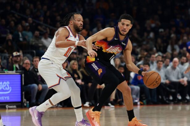 Phoenix, Arizona, USA; Phoenix Suns guard Devin Booker (1) controls the ball against New York Knicks guard Jalen Brunson (11) in the first half at Mortgage Matchup Center. Mandatory Credit: Mark J. Rebilas-Imagn Images