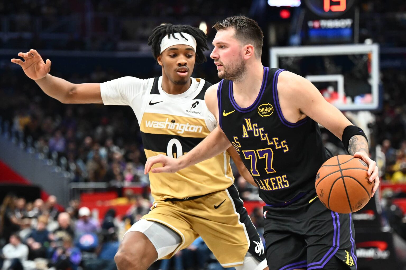 Washington, District of Columbia, USA; Los Angeles Lakers forward/guard Luka Doncic (77) dribbles as Washington Wizards guard Bilal Coulibaly (0) defends during the second half at Capital One Arena. Mandatory Credit: Brad Mills-Imagn Images