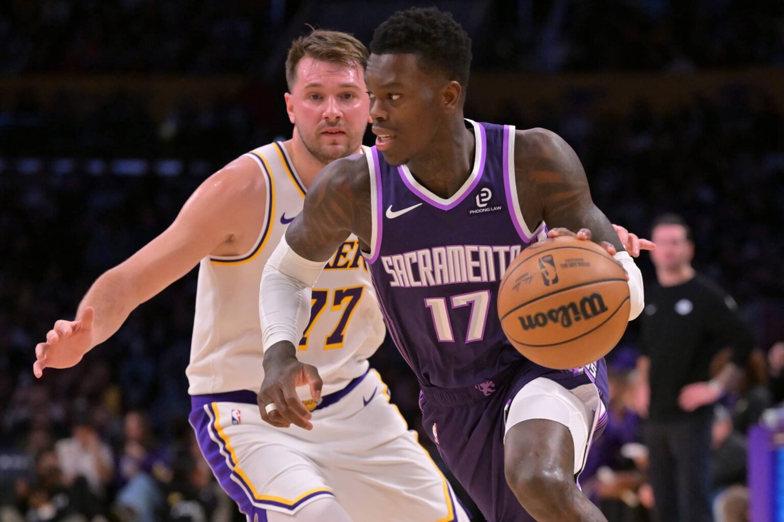 Los Angeles, California, USA; Sacramento Kings guard Dennis Schroder (17) drives past Los Angeles Lakers guard Luka Doncic (77) in the first half at Crypto.com Arena. Mandatory Credit: Jayne Kamin-Oncea-Imagn Images