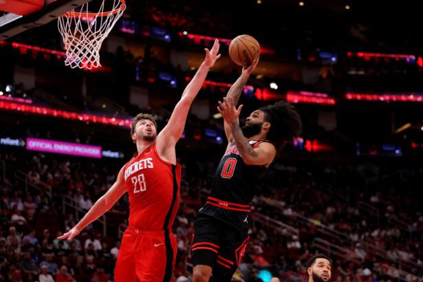 Mar 15, 2025; Houston, Texas, USA; Chicago Bulls guard Coby White (0) drives to the basket against Houston Rockets center Alperen Sengun (28) during the second quarter at Toyota Center. Mandatory Credit: Erik Williams-Imagn Images