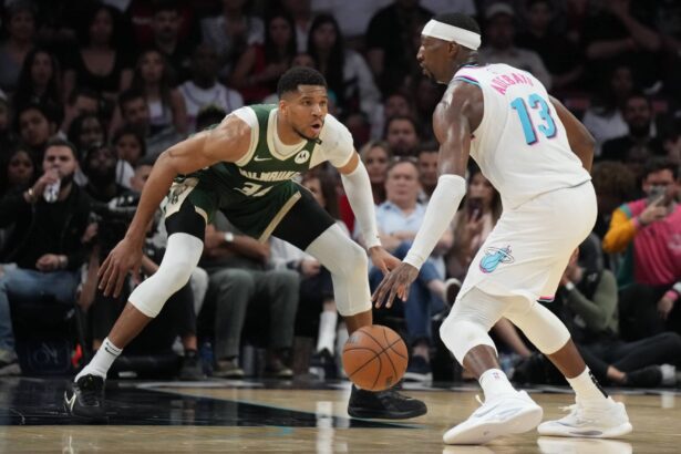 Apr 5, 2025; Miami, Florida, USA; Miami Heat center Bam Adebayo (13) looks to pass the ball as Milwaukee Bucks forward Giannis Antetokounmpo (34) defends during the second half at Kaseya Center. Mandatory Credit: Jim Rassol-Imagn Images