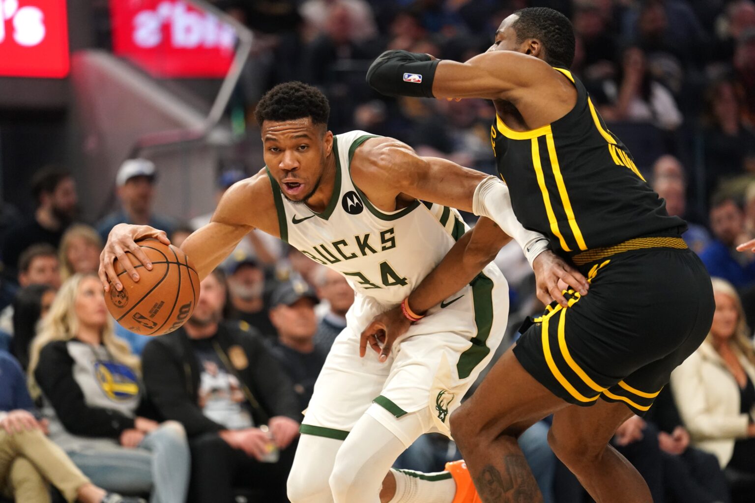 Mar 6, 2024; San Francisco, California, USA; Milwaukee Bucks forward Giannis Antetokounmpo (34) dribbles the ball next to Golden State Warriors forward Jonathan Kuminga (00) in the second quarter at the Chase Center. Mandatory Credit: Cary Edmondson-USA TODAY Sports