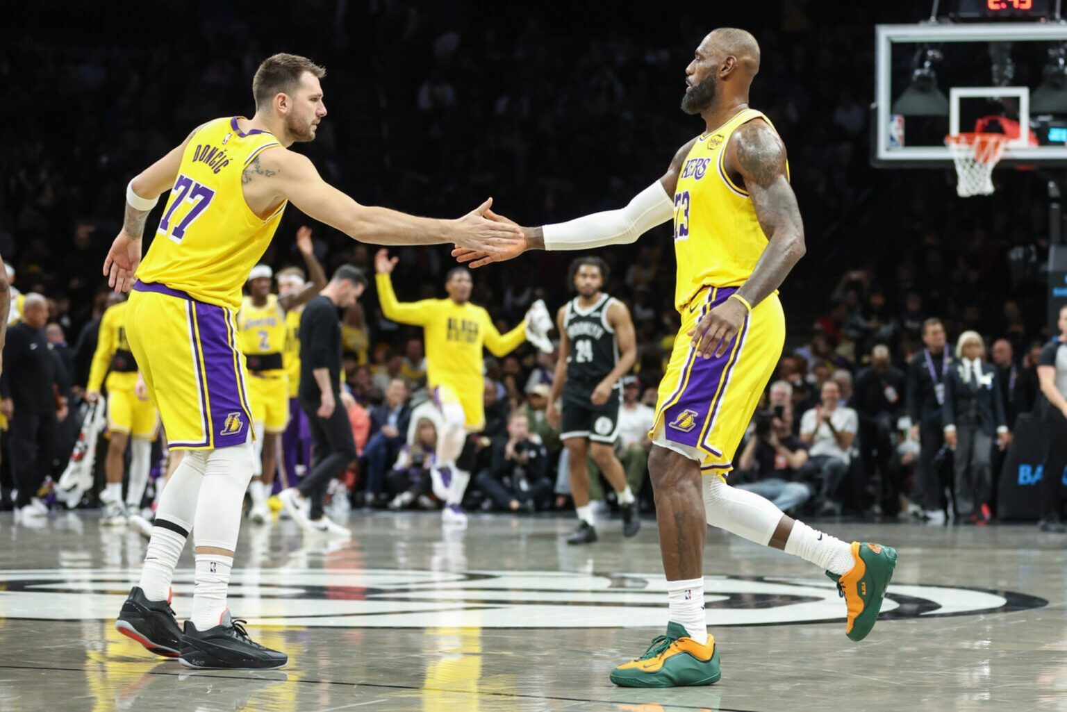 Feb 3, 2026; Brooklyn, New York, USA; Los Angeles Lakers guard Luka Doncic (77) greets forward LeBron James (23) during a timeout in the first quarter against the Brooklyn Nets at Barclays Center. Mandatory Credit: Wendell Cruz-Imagn Images