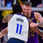 Feb 25, 2025; Los Angeles, California, USA; Los Angeles Lakers guard Luka Doncic (77) reacts with Dallas Mavericks guard Kyrie Irving (11) during the first quarter at Crypto.com Arena. Mandatory Credit: Gary A. Vasquez-Imagn Images