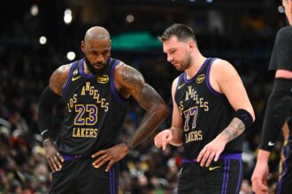Los Angeles Lakers forward/guard Luka Doncic (77) talks with Los Angeles Lakers forward LeBron James (23) against the Washington Wizards during the second half at Capital One Arena.