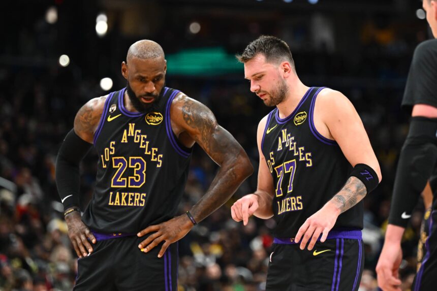 Los Angeles Lakers forward/guard Luka Doncic (77) talks with Los Angeles Lakers forward LeBron James (23) against the Washington Wizards during the second half at Capital One Arena.