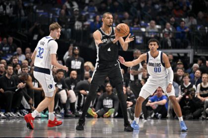 Feb 5, 2026; Dallas, Texas, USA; San Antonio Spurs forward Victor Wembanyama (1) passes the ball by Dallas Mavericks forward Cooper Flagg (32) and guard Max Christie (00) during the first quarter at the American Airlines Center. Mandatory Credit: Jerome Miron-Imagn Images