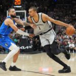 Feb 7, 2026; San Antonio, Texas, USA; San Antonio Spurs forward Victor Wembanyama (1) dribbles against Dallas Mavericks forward Caleb Martin (16) in the first half at Frost Bank Center. Mandatory Credit: Daniel Dunn-Imagn Images