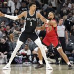 San Antonio Spurs center Victor Wembanyama (1) controls the ball while defended by Houston Rockets guard Dillon Brooks (9) during the first half at Frost Bank Center.