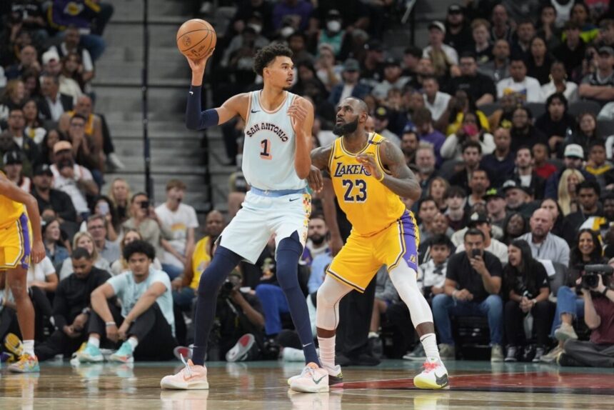 Nov 27, 2024; San Antonio, Texas, USA; San Antonio Spurs center Victor Wembanyama (1) handles the ball in front of Los Angeles Lakers forward LeBron James (23) in the second half at Frost Bank Center. Mandatory Credit: Daniel Dunn-Imagn Images