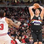 Chicago, Illinois, USA; Denver Nuggets center Nikola Jokic (15) makes a three point basket over Chicago Bulls center Nick Richards (13) during the first half at United Center. Mandatory Credit: David Banks-Imagn Images