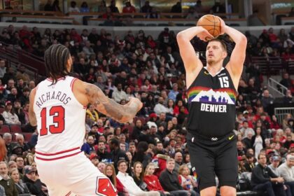 Chicago, Illinois, USA; Denver Nuggets center Nikola Jokic (15) makes a three point basket over Chicago Bulls center Nick Richards (13) during the first half at United Center. Mandatory Credit: David Banks-Imagn Images