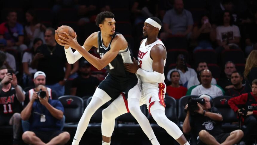 MIAMI, FLORIDA – OCTOBER 15: Victor Wembanyama #1 of the San Antonio Spurs drives against Bam Adebayo #13 of the Miami Heat during the first quarter of a preseason game at Kaseya Center on October 15, 2024 in Miami, Florida. | Credit: Megan Briggs/Getty Images