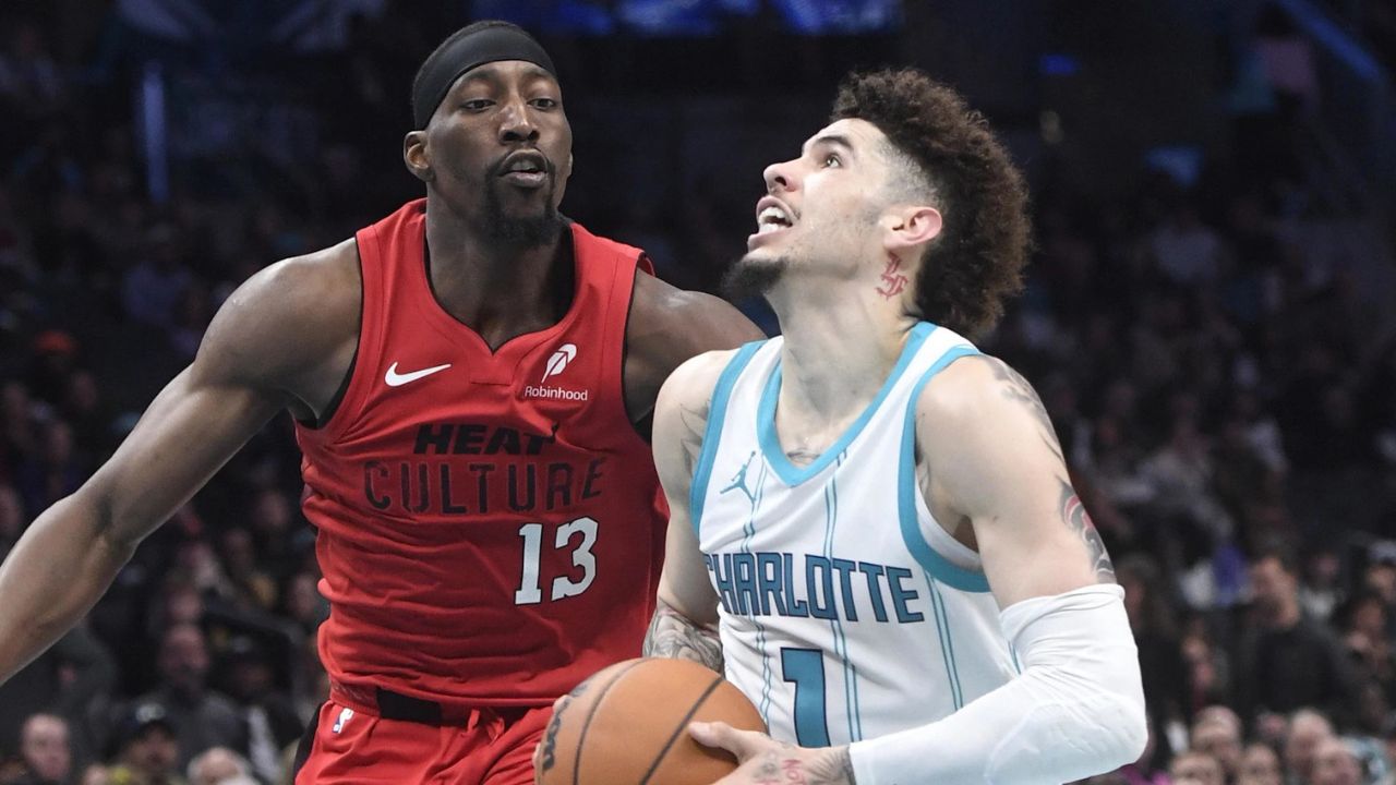Nov 27, 2024; Charlotte, North Carolina, USA; Charlotte Hornets guard LaMelo Ball (1) drives past Miami Heat center/forward Bam Adebayo (13) during the second half at the Spectrum Center. Mandatory Credit: Sam Sharpe-Imagn Images