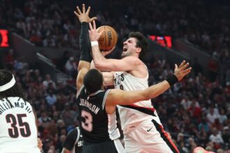 Portland Trail Blazers forward Deni Avdija shoots the ball over San Antonio Spurs forward Keldon Johnson during the first half during game three of the first round of the 2026 NBA Playoffs at Moda Center. Mandatory Credit: Jaime Valdez-Imagn Images