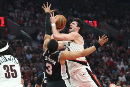 Portland Trail Blazers forward Deni Avdija shoots the ball over San Antonio Spurs forward Keldon Johnson during the first half during game three of the first round of the 2026 NBA Playoffs at Moda Center. Mandatory Credit: Jaime Valdez-Imagn Images