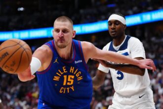 Apr 20, 2026; Denver, Colorado, USA; Minnesota Timberwolves forward Jaden McDaniels (3) defends on Denver Nuggets center Nikola Jokic (15) in the second half during game two of the first round of the 2026 NBA Playoffs at Ball Arena. Credit: Ron Chenoy-Imagn Images