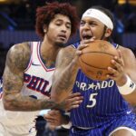 Jan 9, 2026; Orlando, Florida, USA; Orlando Magic forward Paolo Banchero (5) is guarded by Philadelphia 76ers guard Kelly Oubre Jr. (9) in the fourth quarter at Kia Center. Mandatory Credit: Nathan Ray Seebeck-Imagn Images