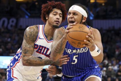 Jan 9, 2026; Orlando, Florida, USA; Orlando Magic forward Paolo Banchero (5) is guarded by Philadelphia 76ers guard Kelly Oubre Jr. (9) in the fourth quarter at Kia Center. Mandatory Credit: Nathan Ray Seebeck-Imagn Images