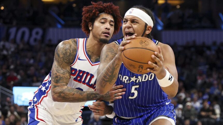 Jan 9, 2026; Orlando, Florida, USA; Orlando Magic forward Paolo Banchero (5) is guarded by Philadelphia 76ers guard Kelly Oubre Jr. (9) in the fourth quarter at Kia Center. Mandatory Credit: Nathan Ray Seebeck-Imagn Images