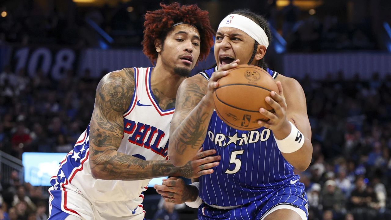 Jan 9, 2026; Orlando, Florida, USA; Orlando Magic forward Paolo Banchero (5) is guarded by Philadelphia 76ers guard Kelly Oubre Jr. (9) in the fourth quarter at Kia Center. Mandatory Credit: Nathan Ray Seebeck-Imagn Images