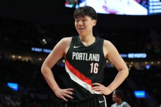 Feb 7, 2026; Portland, Oregon, USA; Portland Trail Blazers center Yang Hansen (16) reacts to a call during the first half against the Memphis Grizzlies at Moda Center. Mandatory Credit: Soobum Im-Imagn Images