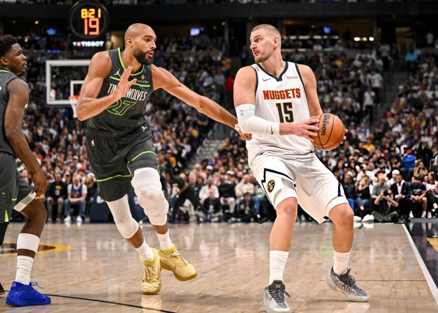 DENVER , CO - APRIL 18: Nikola Jokic (15) of the Denver Nuggets handles as Rudy Gobert (27) of the Minnesota Timberwolves defends during the fourth quarter of the Nuggets' 116-105 win at Ball Arena in Denver, Colorado on Saturday, April 18, 2026. The Nuggets took a 1-0 lead in their best-of-seven series. (Photo by AAron Ontiveroz/The Denver Post)