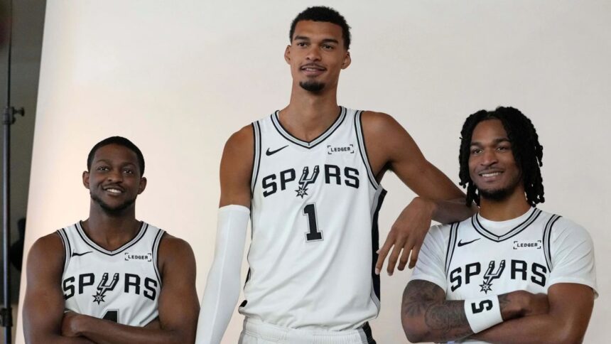 Sep 29, 2025; San Antonio, TX, USA; San Antonio Spurs forward-center Victor Wembanyama (1) along with guards De’Aaron Fox (4) and Stephon Castle (5) pose for photos during Media Day at Victory Capital Performance Center in San Antonio. Mandatory Credit: Scott Wachter-Imagn Images
