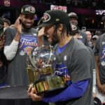 New York Knicks guard Jalen Brunson, center, holds the Eastern Conference Championship trophy after Game 4 in the Eastern Conference finals NBA basketball playoffs series against the Cleveland Cavaliers in Cleveland, Monday, May 25, 2026. (AP Photo/Sue Ogrocki)