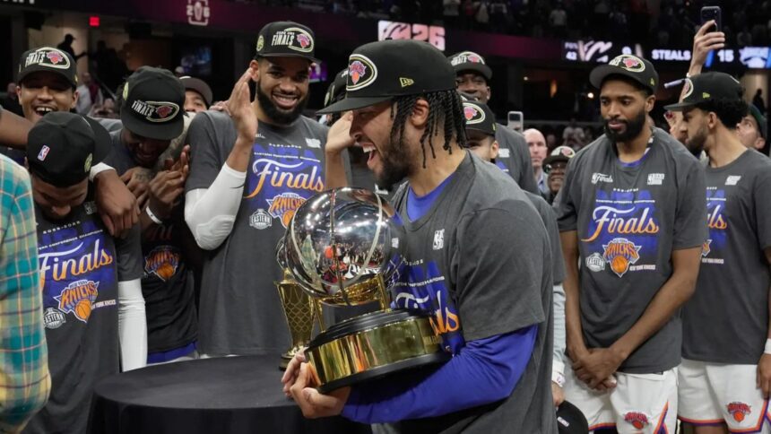New York Knicks guard Jalen Brunson, center, holds the Eastern Conference Championship trophy after Game 4 in the Eastern Conference finals NBA basketball playoffs series against the Cleveland Cavaliers in Cleveland, Monday, May 25, 2026. (AP Photo/Sue Ogrocki)