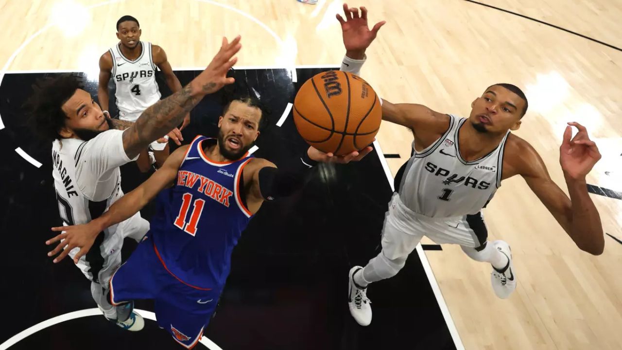 New York’s Jalen Brunson shoots between San Antonio’s Julian Champagnie, left, and Victor Wembanyama during the fourth quarter of the Knicks’ 105-104 win in Game 2 of the NBA Finals on Friday night. (Gregory Shamus / Getty Images)