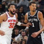 San Antonio Spurs center Victor Wembanyama (1) guards New York Knicks center Karl-Anthony Towns during the second half of an NBA basketball game, Wednesday, Dec. 31, 2025, in San Antonio. (AP Photo/Darren Abate)