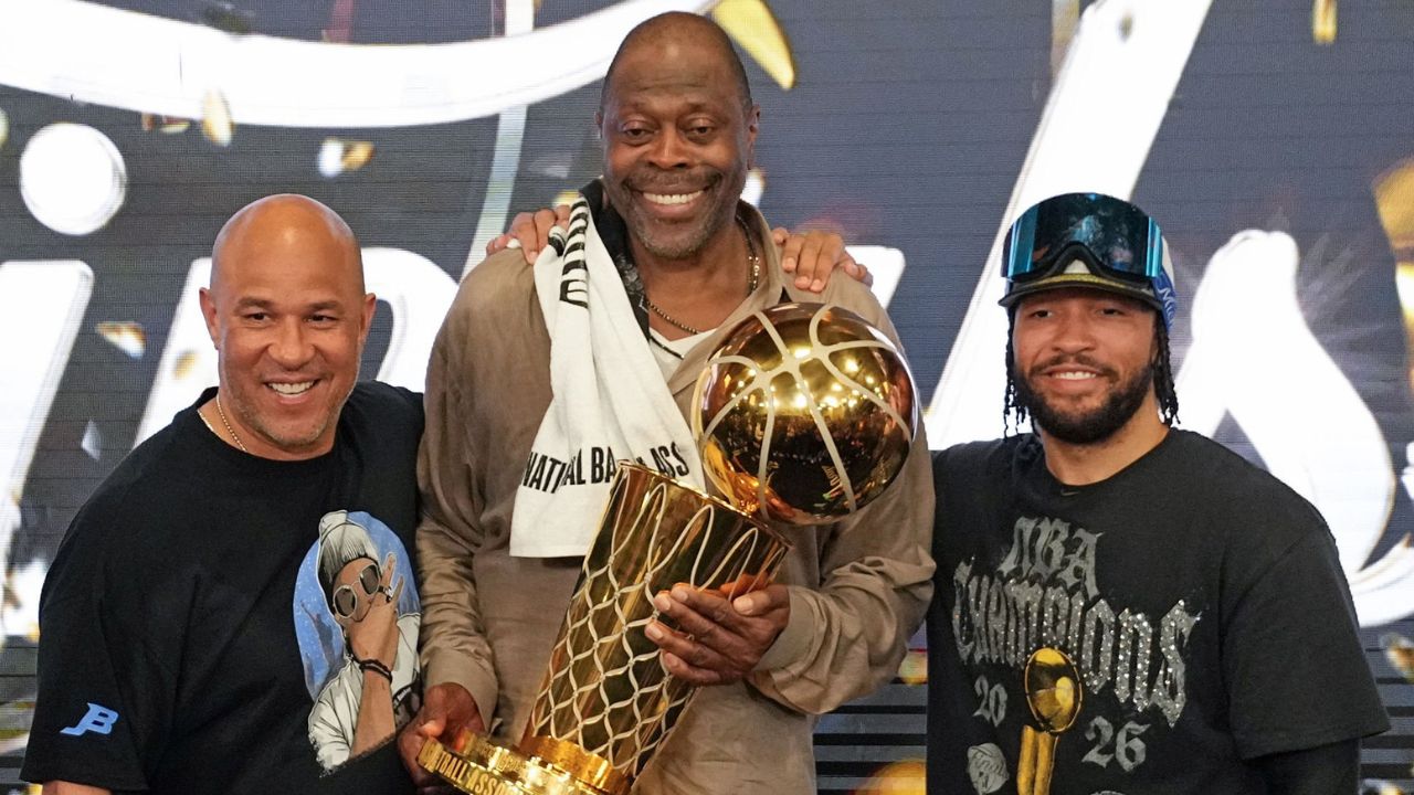 SAN ANTONIO, TX - JUNE 13: Assistant Coach Rick Brunson, Patrick Ewing, Jalen Brunson #11 of the New York Knicks pose for a photo with the Larry O'Brien Championship Trophy during Game Five of the 2026 NBA Finals on June 13, 2026 at Frost Bank Center in San Antonio, Texas. (Photo by Jesse D. Garrabrant /NBAE via Getty Images)