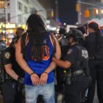 NYPD officers make an arrest after thousands of Knicks fans flooded the streets damaging a police van and a taxi following a historic comeback win against San Antonio Spurs in the NBA Finals Game 4 at Madison Square Garden on June 10, 2026.