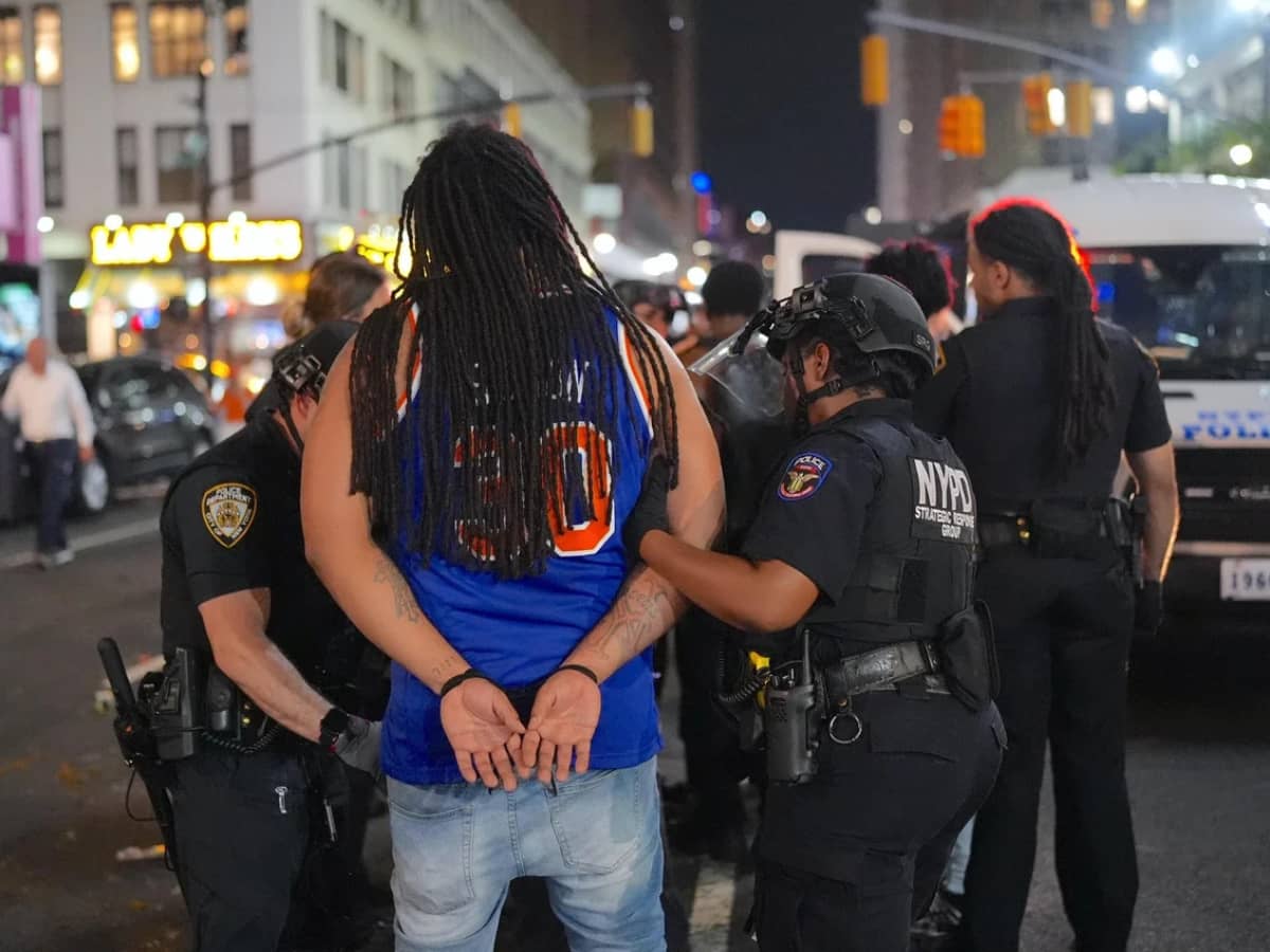 NYPD officers make an arrest after thousands of Knicks fans flooded the streets damaging a police van and a taxi following a historic comeback win against San Antonio Spurs in the NBA Finals Game 4 at Madison Square Garden on June 10, 2026.