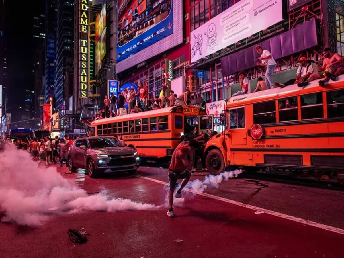 A person kicks a smoke canister as New York Knicks fans celebrate their win against San Antonio Spurs in Game 5 of the NBA Finals in Times Square on June 14, 2026 in New York City.