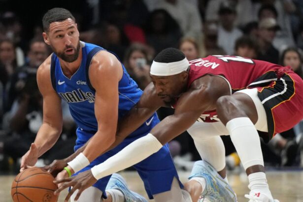 Nov 24, 2025; Miami, Florida, USA; Dallas Mavericks guard Klay Thompson (31) and Miami Heat center Bam Adebayo (13) battle for a loose ball during the second half at Kaseya Center. Mandatory Credit: Jim Rassol-Imagn Images