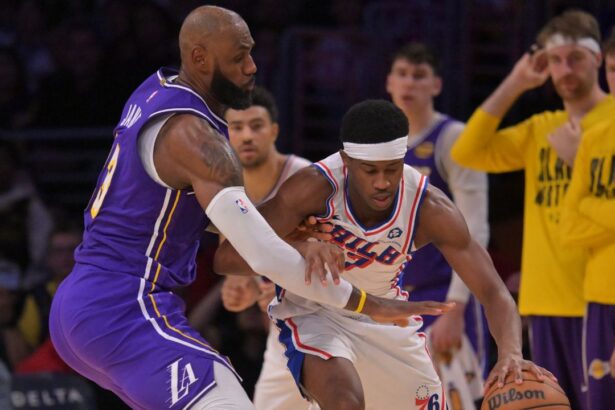 Feb 5, 2026; Los Angeles, California, USA; Los Angeles Lakers forward LeBron James (23) defends Philadelphia 76ers guard Vj Edgecombe (77) in the second half at Crypto.com Arena. Mandatory Credit: Jayne Kamin-Oncea-Imagn Images