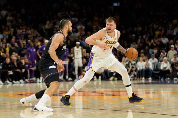 Phoenix, Arizona, USA; Los Angeles Lakers guard Luka Doncic (77) dribbles the ball as Phoenix Suns forward Dillon Brooks (3) defends during the second half of play at Mortgage Matchup Center. Mandatory Credit: Allan Henry-Imagn Images
