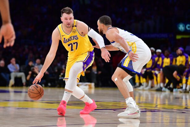 Apr 3, 2025; Los Angeles, California, USA; Los Angeles Lakers guard Luka Doncic (77) moves the ball against Golden State Warriors guard Stephen Curry (30) during the first half at Crypto.com Arena. Mandatory Credit: Gary A. Vasquez-Imagn Images